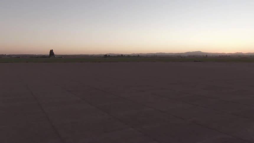 Mountains and rock formations standing against a red horizon tower over a flat landscape