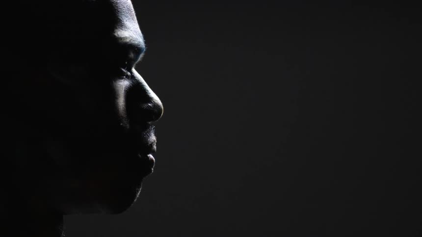 A black man is staring forward unmoving
