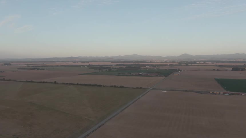 Aerial landscape of agricultural fields and mountains on the horizon