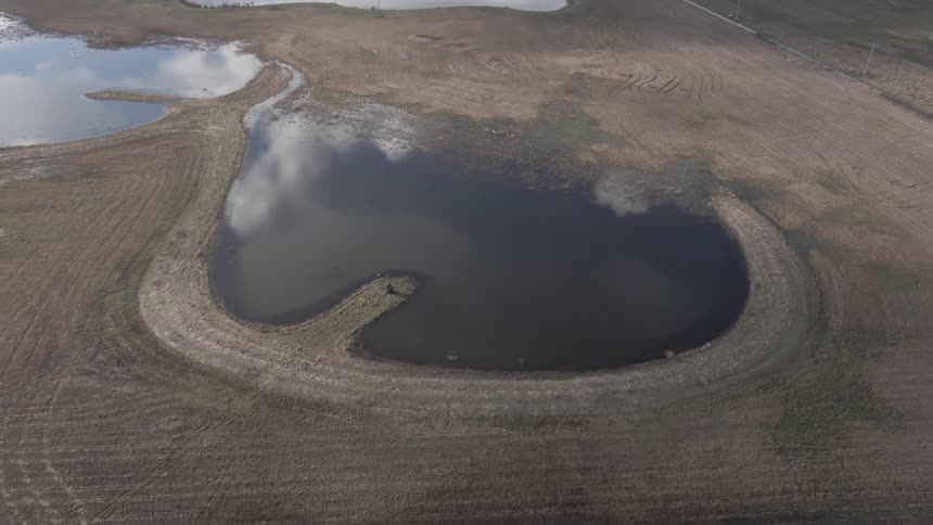 A pool of water is in the middle of the farm