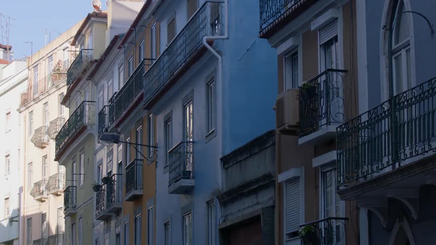 Row houses with iron railing balconies in shade
