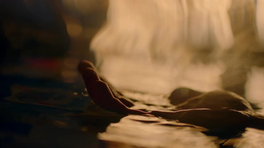 A persons hand is floating in the water