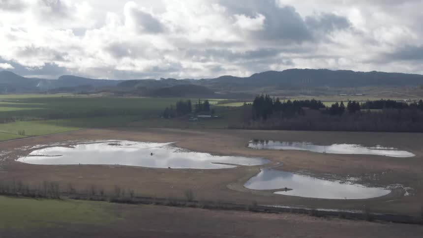 Scenery of lakes in a region of fields and mountains in the background