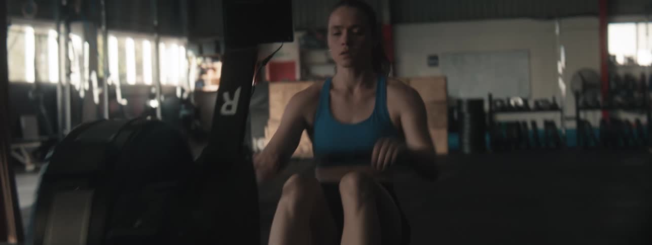 Woman in a crossfit gym interacting with an ergonomic device