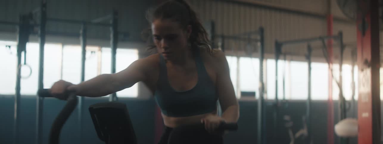 A woman working out on a stationary bike at the gym