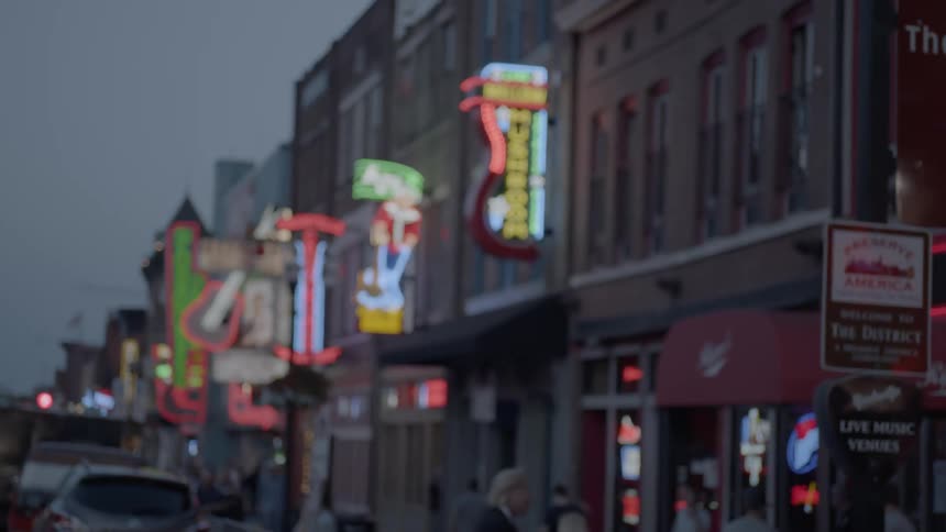 A busy street lined with neon signs