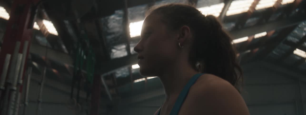 Close up of a young woman walking around in an indoor gym