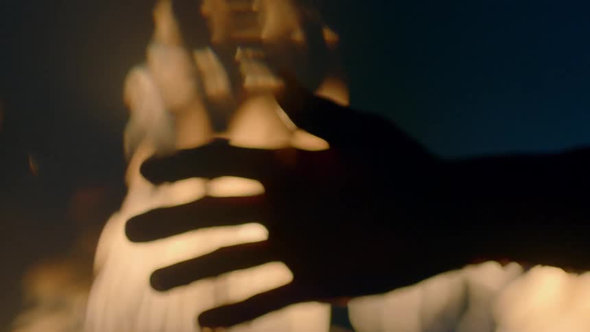 Water drips from a hand with flames in the background