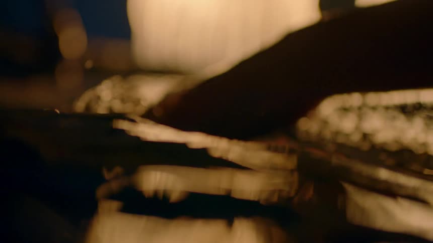 A hand splashes into water and then lifts out