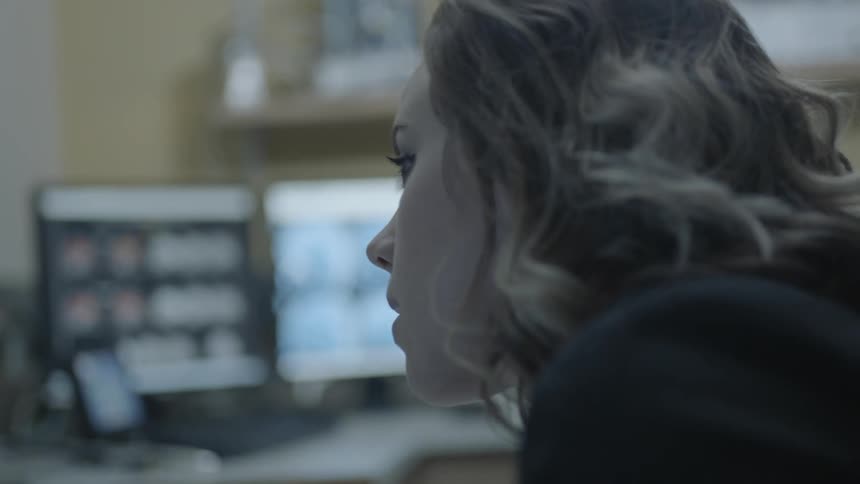 A woman looks down and talks into a mic