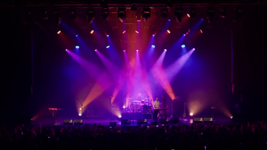 A rock band performing on a stage at night