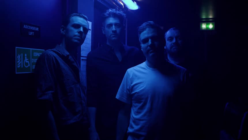 Four men standing backstage at a nightclub