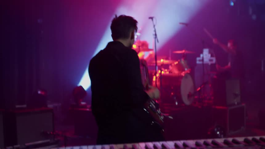 Multiple drummers and guitarists play during the performance of a rock band