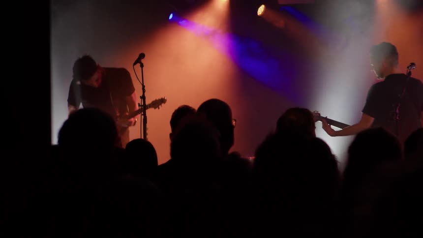 A man is singing to the audience with his band
