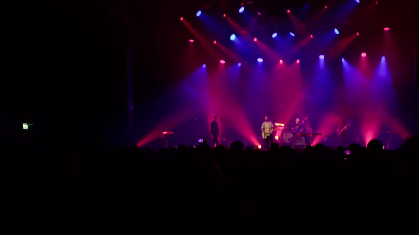 Silhouette of people at a concert following a band