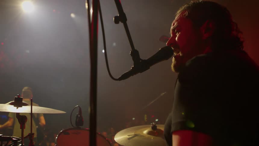 Band performing in an auditorium with a crowd of people