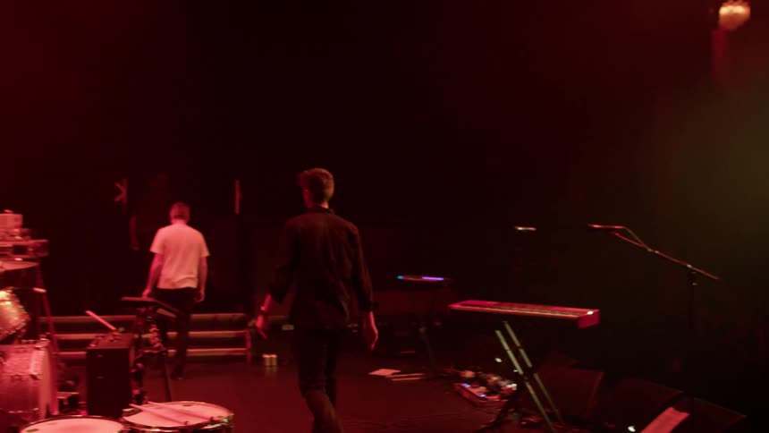 A band on stage saying goodbye to the audience and leaving the stage