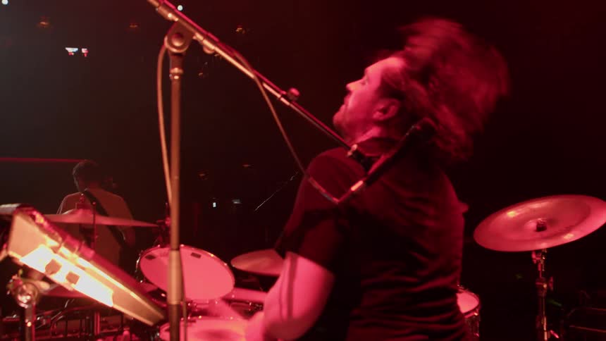 The drummer is performing behind the band