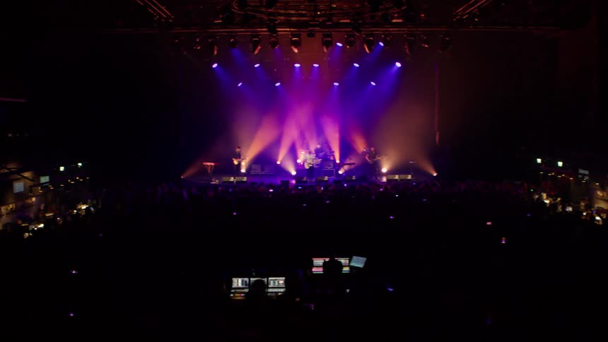 A band playing on a stage for a large crowd