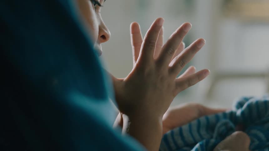 A child is holding his hands together