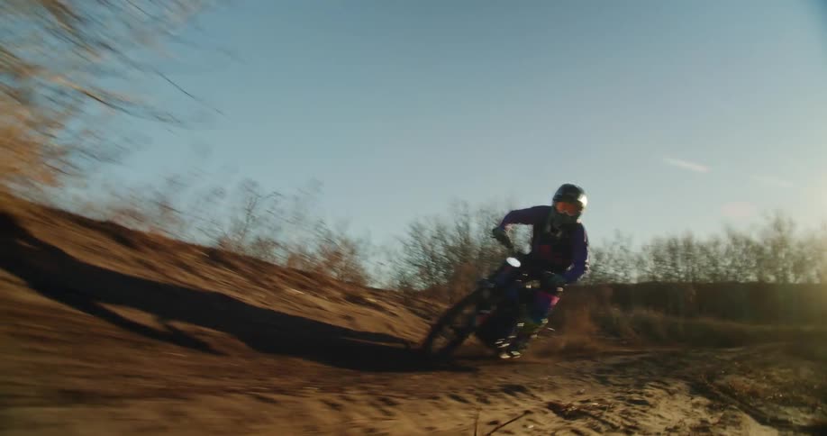 Dirtbiker speeds though a sandy banked corner