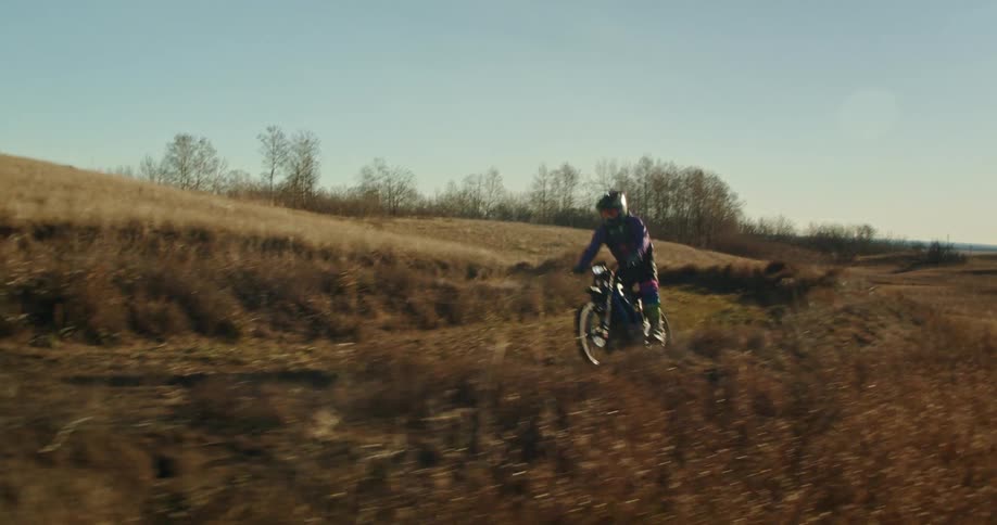 A man racing on a rally motorcycle during a competition