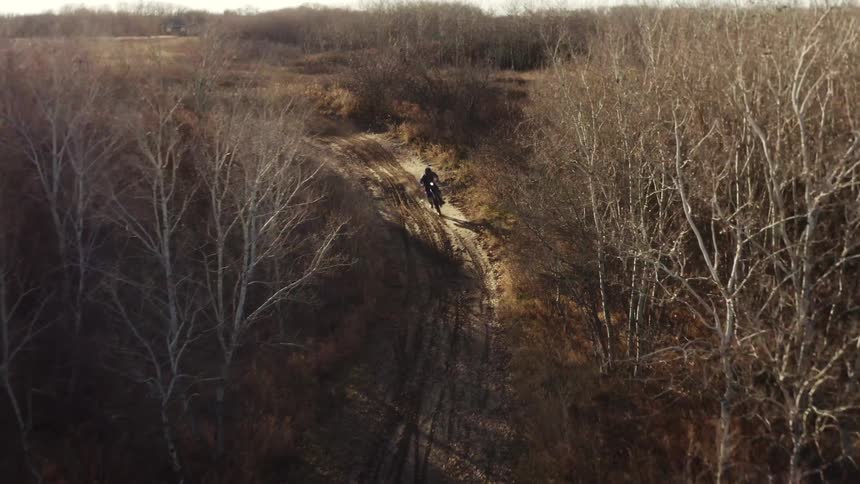 Person riding motocross on a trail in the forest