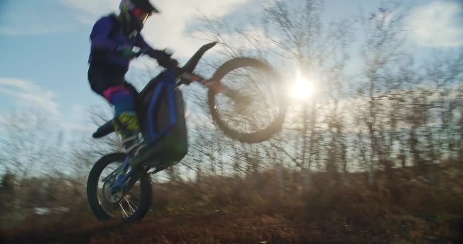 Man does wheelie over hill on dirtbike