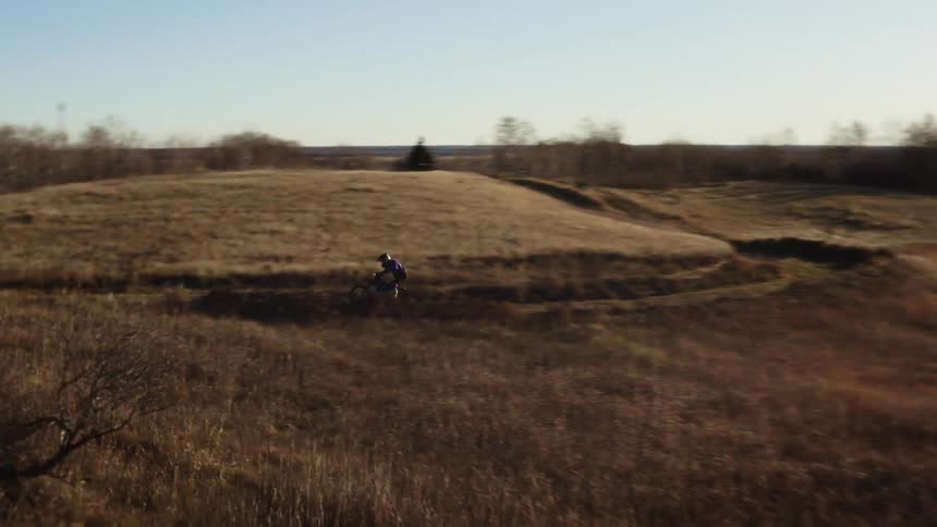 Man races around field road on a dirt bike