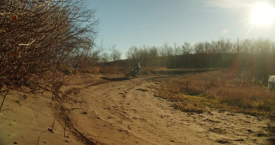 Man riding dirtbike around banked corner at high speed