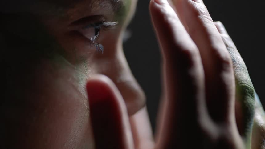 A person removes their hands from their face