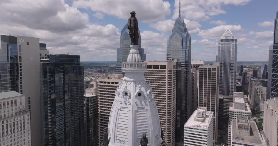 Aerial view of William Penn atop Philadelphia city hall encircled by skyscrapers