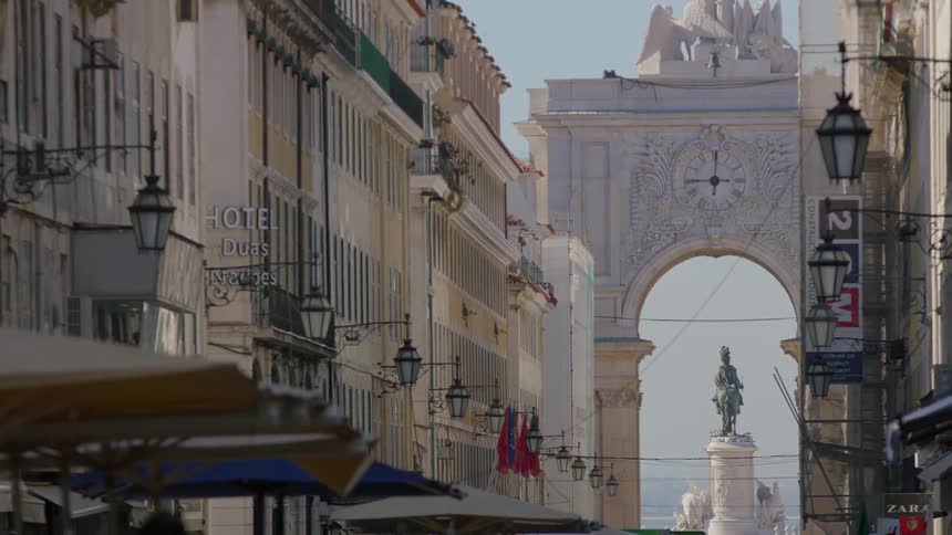 Pedestrians walk through a street in an old city