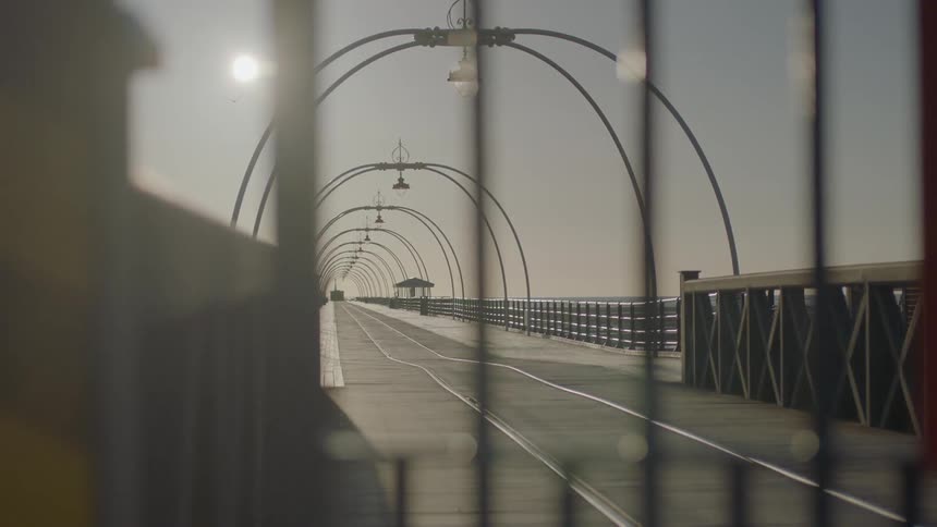 A walkway with arches is shown on a sunny day