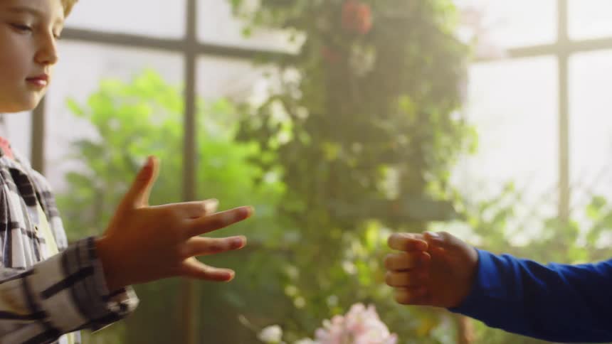 A little boy is happy while shaking hands with an adult in front of him