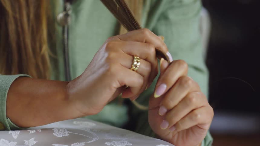 A woman brushes her hair with her hand