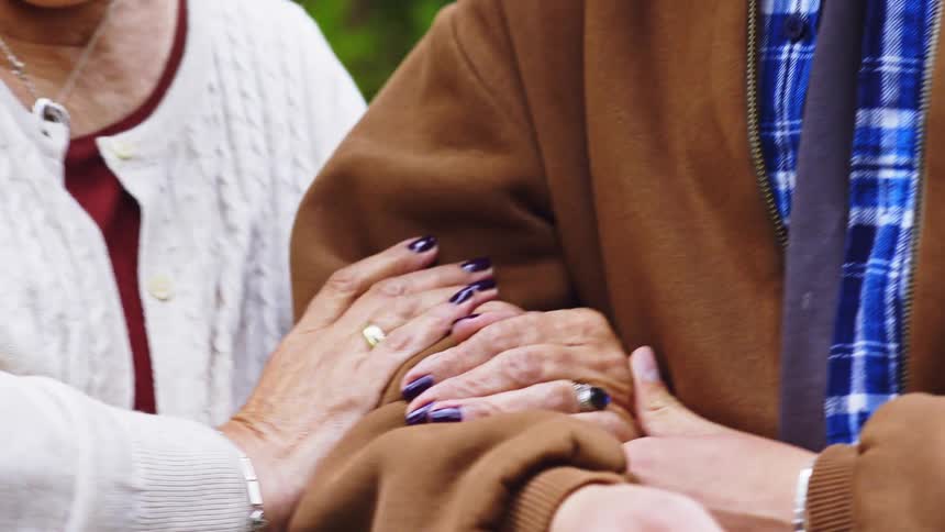 A woman helps an elderly person walk