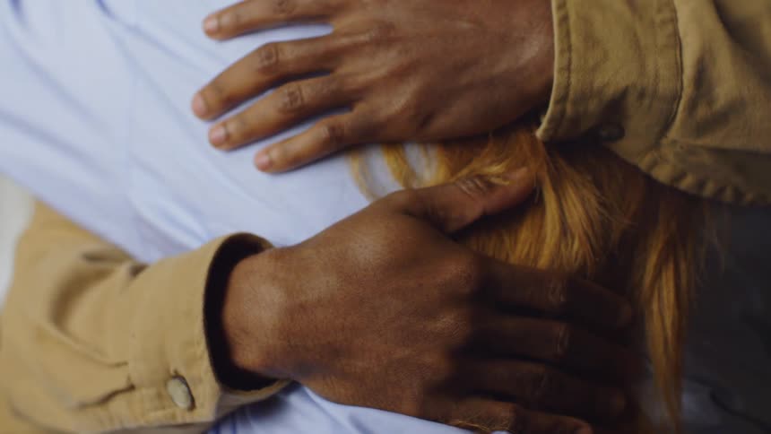 A man hugs a woman tightly with eyes closed showing deep emotion