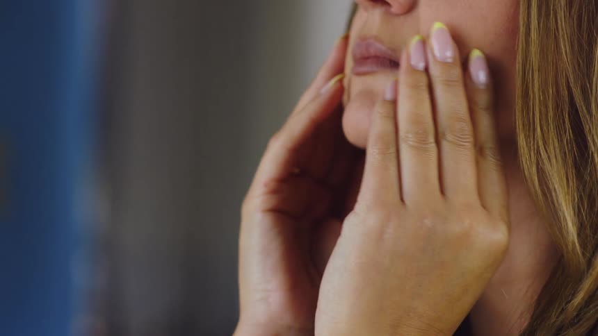 A woman covers her face with her hands