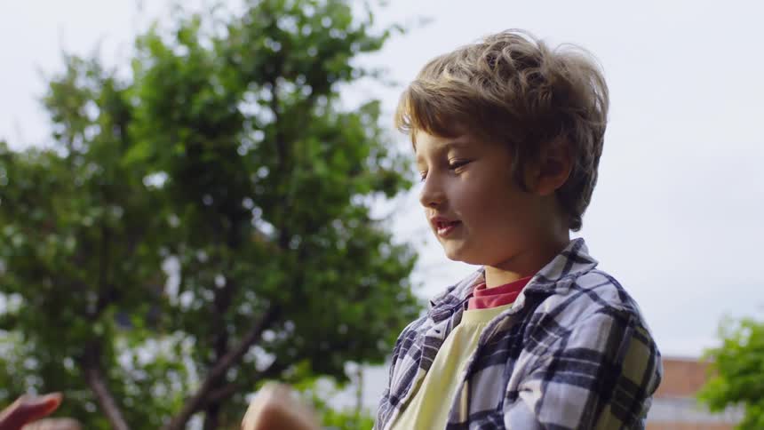 A child plays rockpaperscissors outdoors with another person