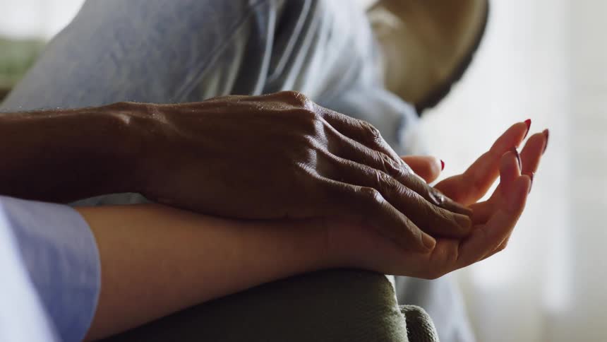 Hands of two people of different shades together