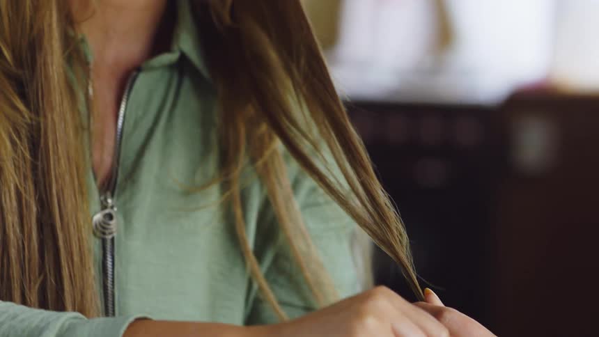 A woman smoothing her hair and smelling it