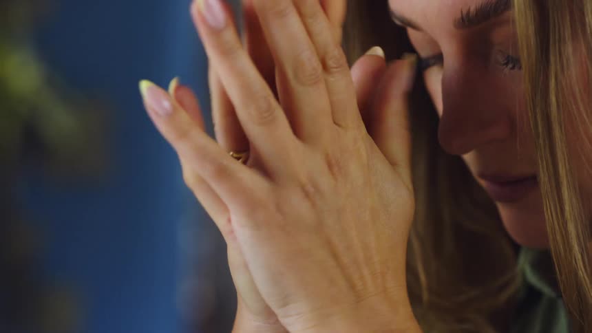 A woman rubs her face and looks worried