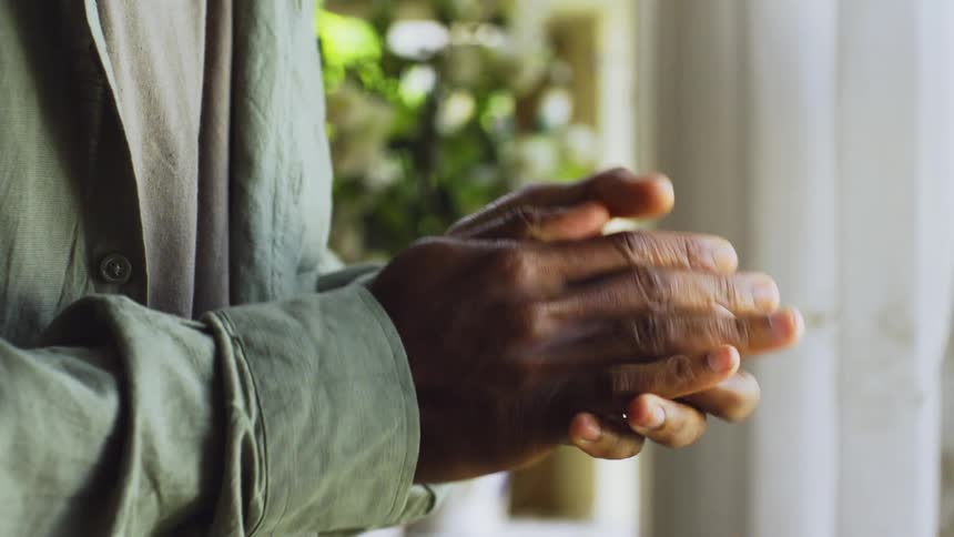 Closeup of a pair of hands of a person clasped together and apprehensive