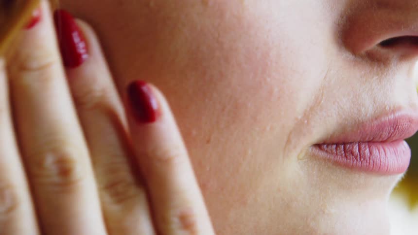 Sad woman wiping tears away falling on her cheeks