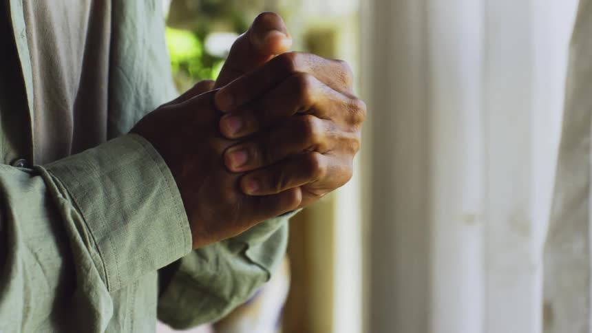 The hands of a person who is wearing long sleeves and is rubbing their fingers together