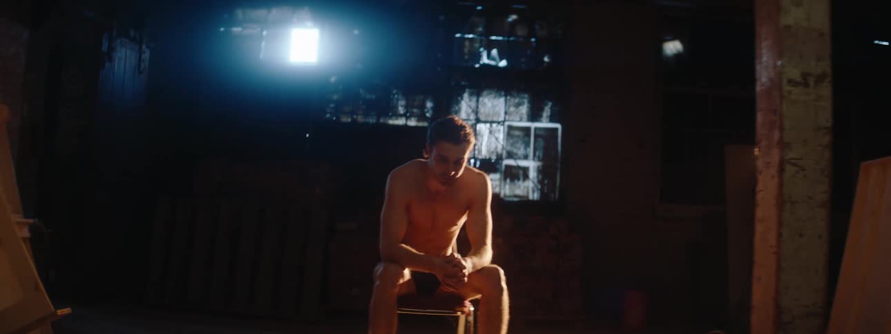 A man is sitting under a spot light
