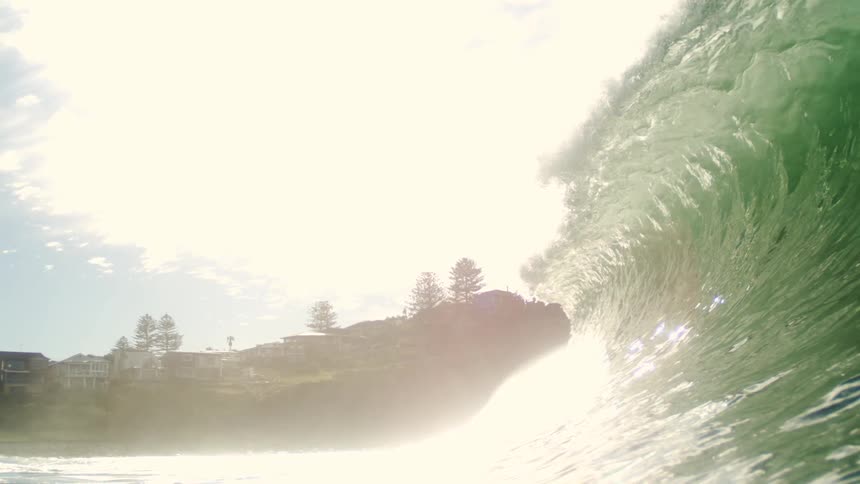 Crystal clear green wave breaking in the ocean