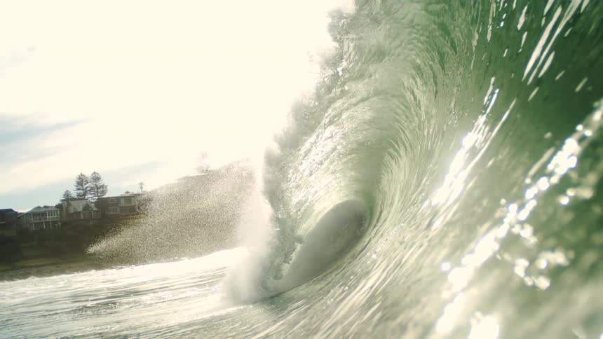 A large wind wave lands by the homes on the shore