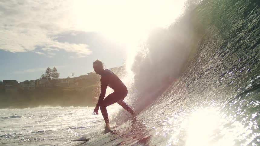 Silhouette of surfers riding the same wave in opposite directions